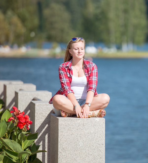 young adult sitting on pier