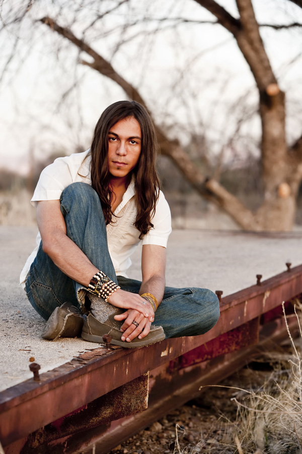 young man sitting on old railroad bed