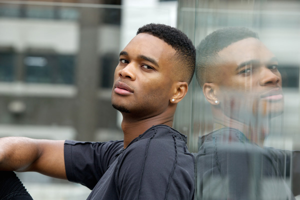 portrait of young person with reflection on glass building