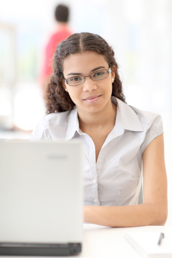 young adult sitting at laptop computer