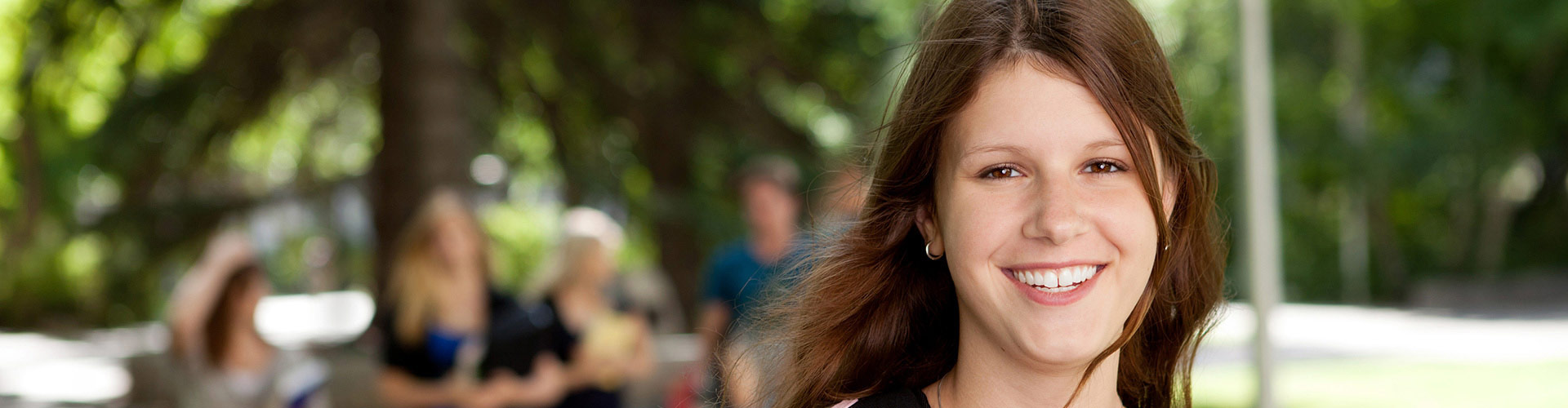 Portrait of smiling young college student outside